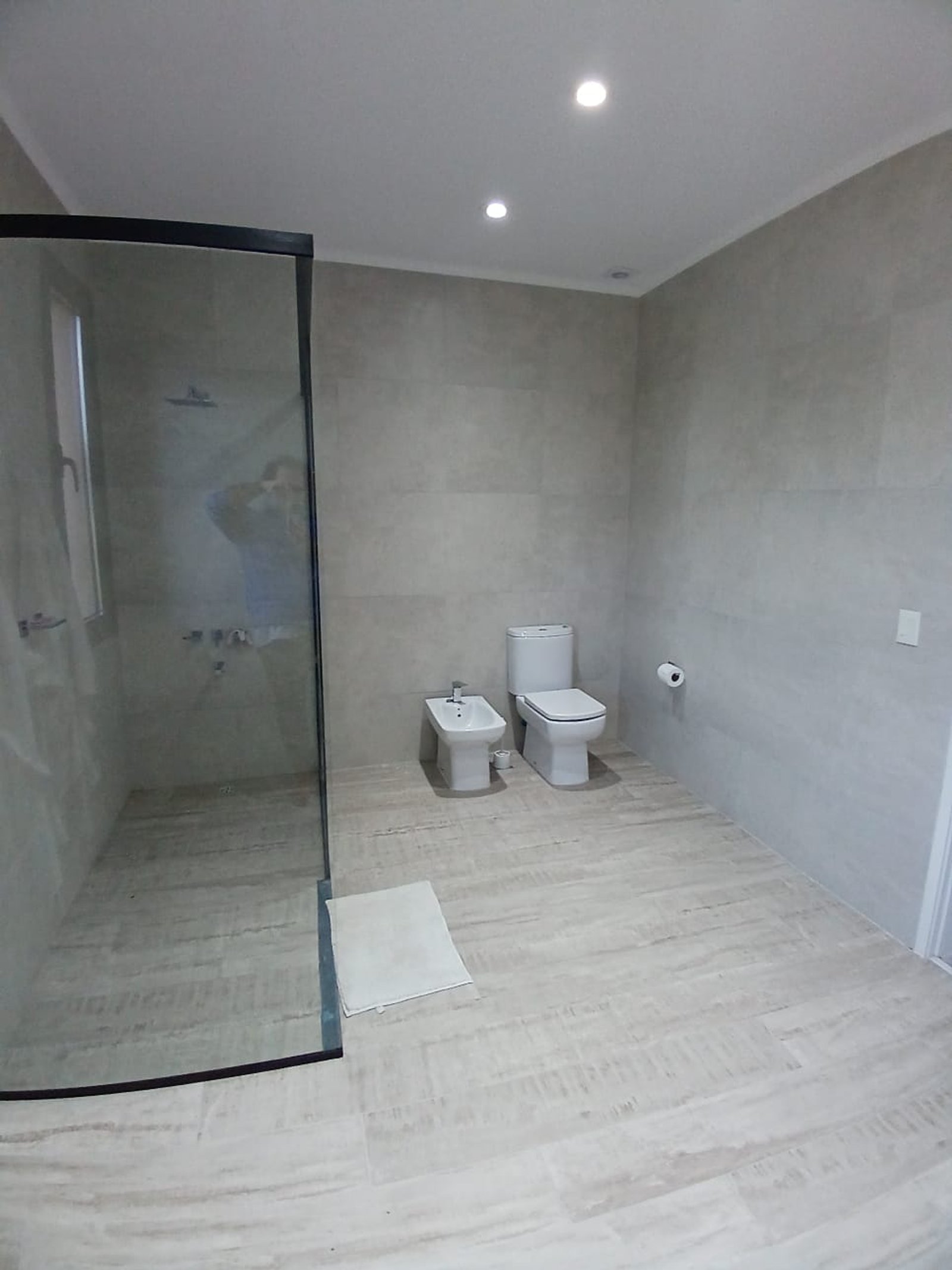 Baño moderno con ducha de vidrio y revestimientos grises — proyecto CASA A Y M, por Sep Arquitectura , en Ruta 205 Km 53